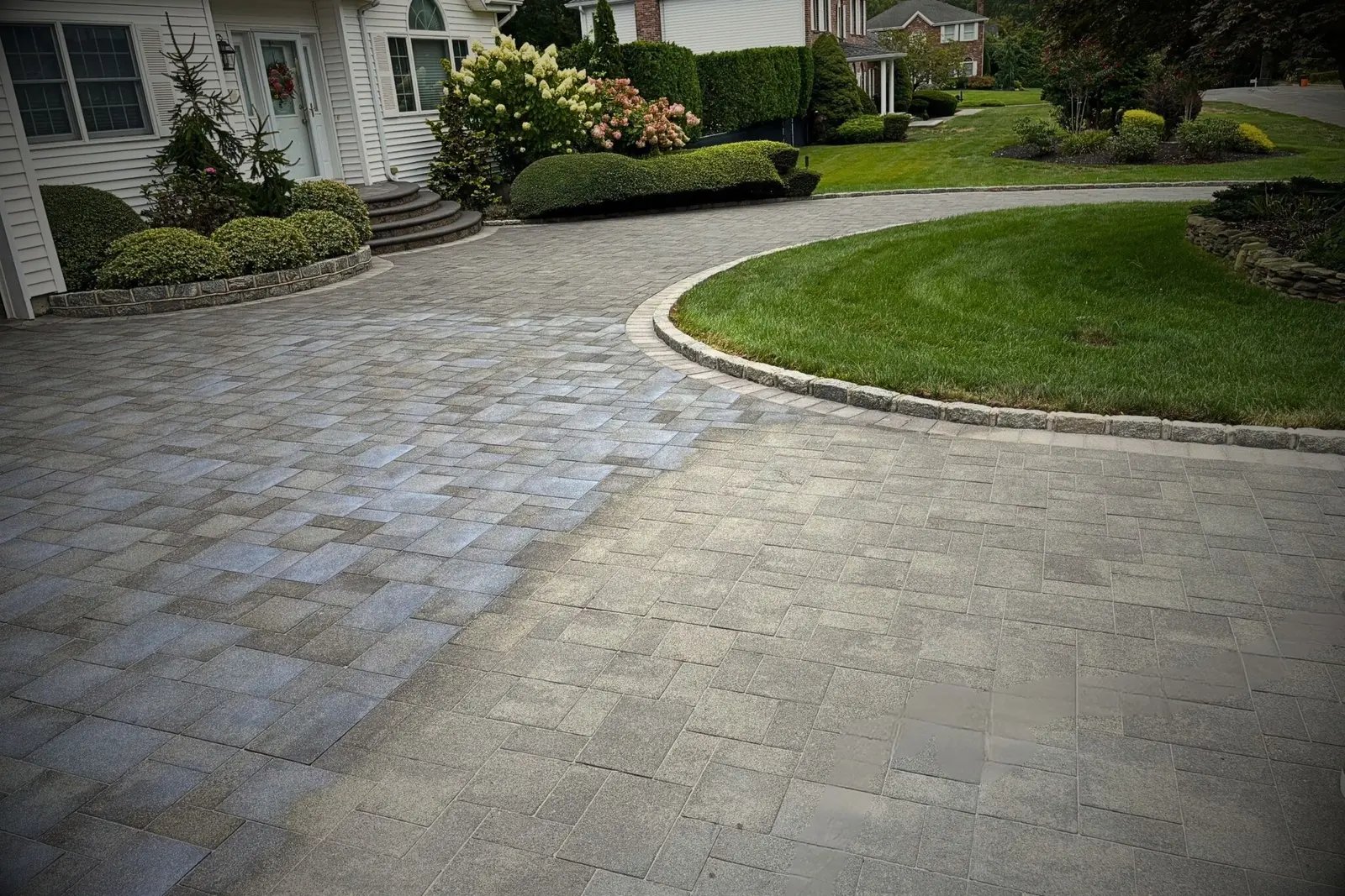 Paver driveway half cleaned showing the difference